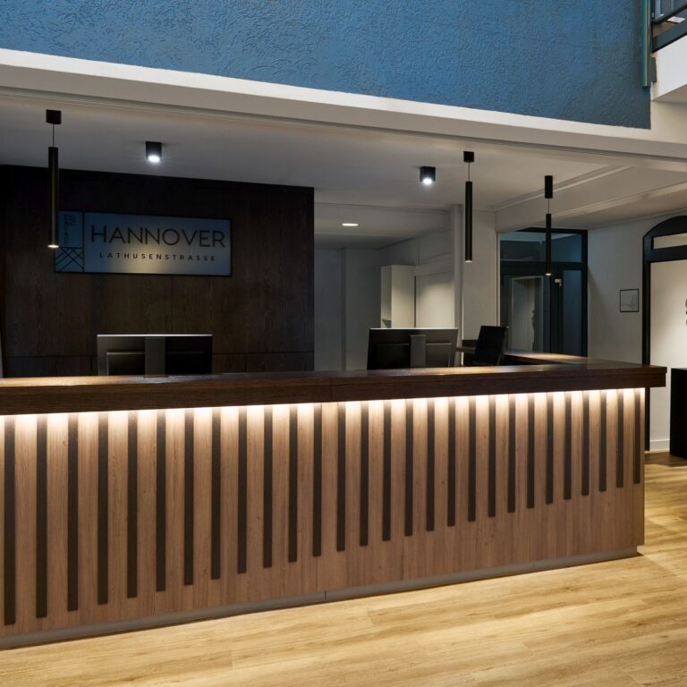 Helle Hotel-Lobby mit Empfangstheke und modernen Sitzgelegenheiten.